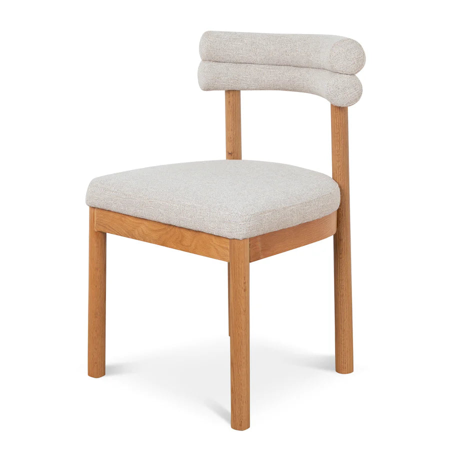 Angled view of Coper Dining Chair highlighting cushioned backrest, smooth curves, and minimalist frame