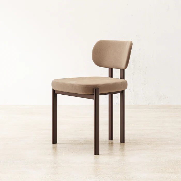 Angled view of Coral Dining Chair highlighting soft fabric backrest and sleek minimalist profile