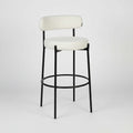Angled view of Elora Bar Stool highlighting curved cushioned backrest and minimalist structure