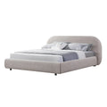 Angled view of Merida Bed showcasing its plush half-moon headboard and curved upholstered structure