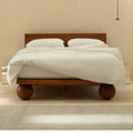 Straight-on image of Orion Wooden Bed emphasizing slatted headboard and timeless minimalist form