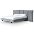 Angled view of Premiere Bed showcasing vertical tufting, soft upholstery, and modern frame proportions
