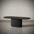 Asta Oval Dining Table in black engineered wood with hand-carved fluted legs