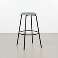 Angled view of Velora Bar Stool highlighting rounded upholstered seat and modern minimalist form