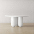 Front view of Finral round dining table with high-gloss white finish and sculptural cylinder legs