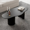 Legia dining table in black with organic top and sculptural base top SIde View in Living room setting