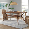 Rowena solid wood dining table with sculpted trestle-style legs in living room